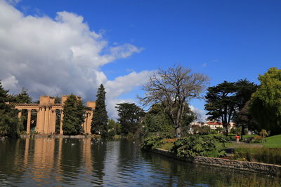 Panoramic view of park by river against blue sky