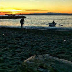 Silhouette of people in sea at sunset