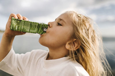 Side view of girl drinking from