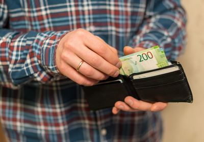 Midsection of man removing paper currencies from wallet