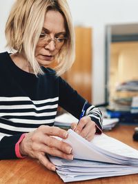 Young woman writing in book at office