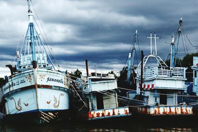 Ship moored at harbor against sky