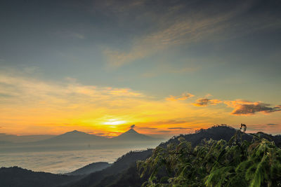 Scenic view of mountains against orange sky