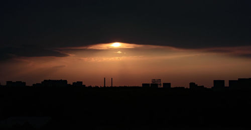 Silhouette buildings against sky during sunset