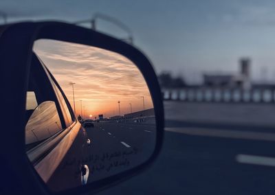 Car on street against sky during sunset