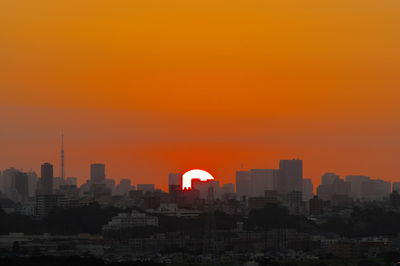 Silhouette buildings against romantic sky at sunset