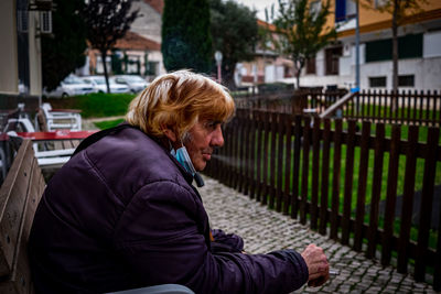 Side view of man sitting on snow