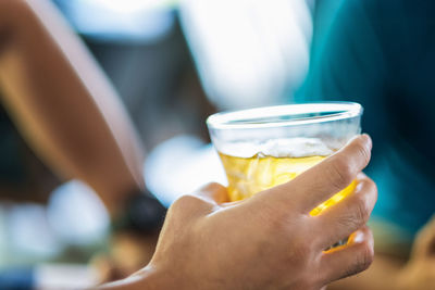 Close-up of hand holding beer glass