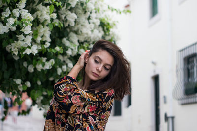 Young woman with hand in hair looking down