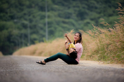 Portrait of mother with son sitting on road