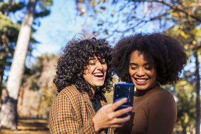Portrait of smiling young woman using smart phone