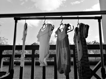 Low angle view of clothes hanging on rack against sky