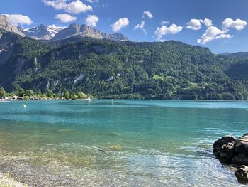 Scenic view of lake by mountains against sky