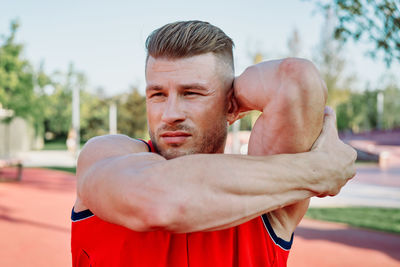 Portrait of young man exercising in park