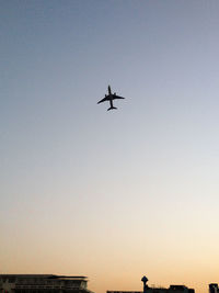 Low angle view of silhouette airplane against clear sky