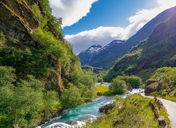 Scenic view of river amidst mountains against sky