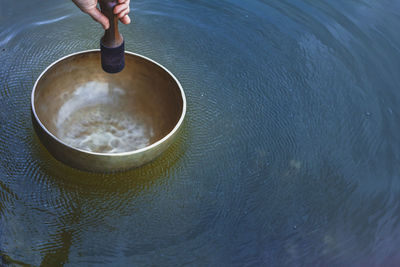 Tibetan singing bowl floating on water with vibration