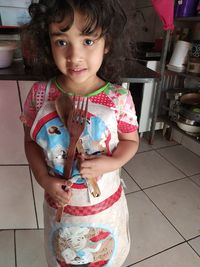 Portrait of cute girl standing on floor at home