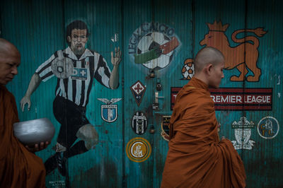 Monks walking by wall