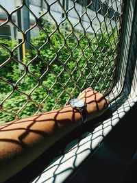 Close-up of woman seen through chainlink fence
