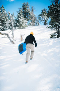 Rear view of man walking on snow covered mountain