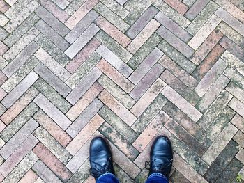 Low section of person standing on cobblestone street