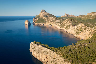 Scenic view of sea and mountains against clear blue sky