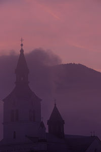 Church by building against sky during sunset