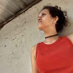 Close-up of young woman standing against wall