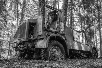 Abandoned truck on field in forest