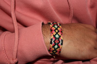 Close-up of man hand holding multi colored umbrella