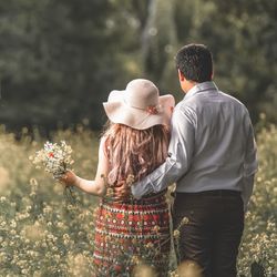 Rear view of couple kissing against plants