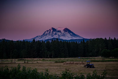 Scenic view of field and mountains against sky during sunset