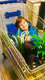 Portrait of smiling boy sitting in shopping cart