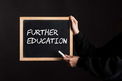 Midsection of man holding blackboard