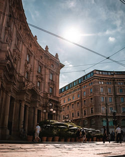 People walking on street amidst buildings in city