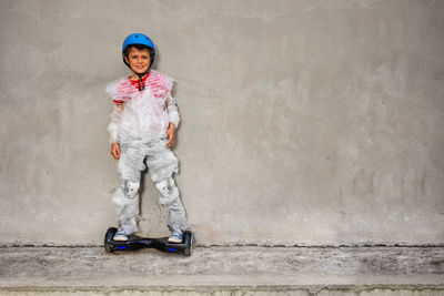 Portrait of boy standing against wall