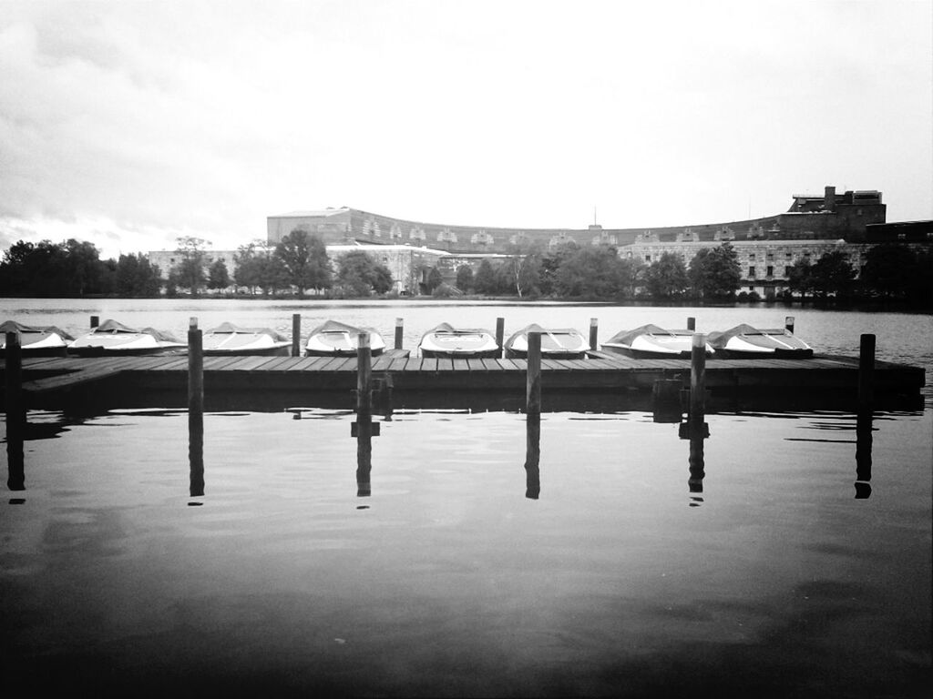 water, built structure, architecture, clear sky, river, transportation, copy space, waterfront, bridge - man made structure, building exterior, connection, reflection, sky, day, outdoors, pier, in a row, no people, nature, tranquility