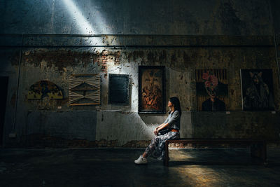 Woman sitting on abandoned building