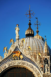 Statues and carvings on saint mark basilica against clear blue sky