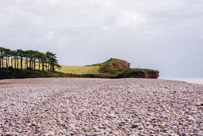 Stone wall on beach against sky