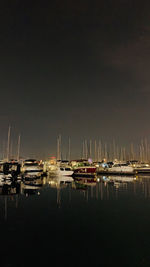 Sailboats moored in harbor at night