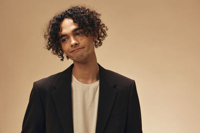 Sad young man against beige background