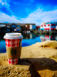 Close-up of coffee on beach against sky