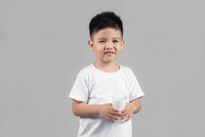 Portrait of boy standing against white background