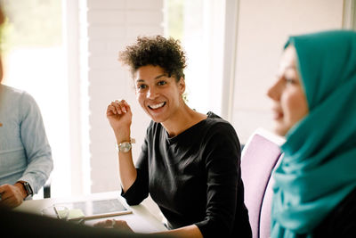 Smiling businesswoman discussing during meeting in convention center