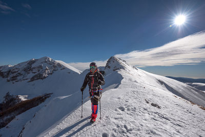 People skiing on snowcapped mountain against sky