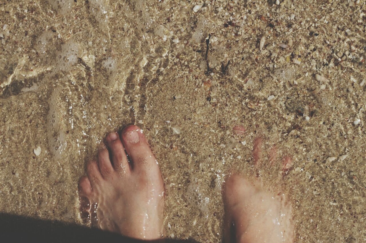 low section, person, personal perspective, sand, human foot, beach, barefoot, lifestyles, high angle view, leisure activity, part of, unrecognizable person, shore, standing, sunlight, directly above