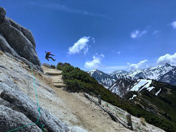 Man rock on mountain against sky