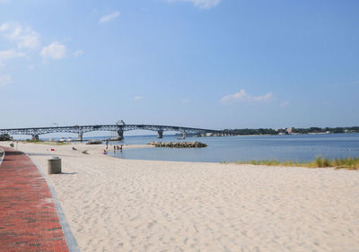 Bridge over sea against sky during sunny day